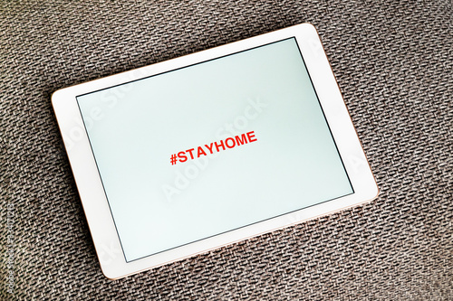 Stay Home inscription on tablet, mobile phone. Concept how to stop the coronavirus from spreadin. Stay at home advice to stop coronavirus COVID-19 spreading photo