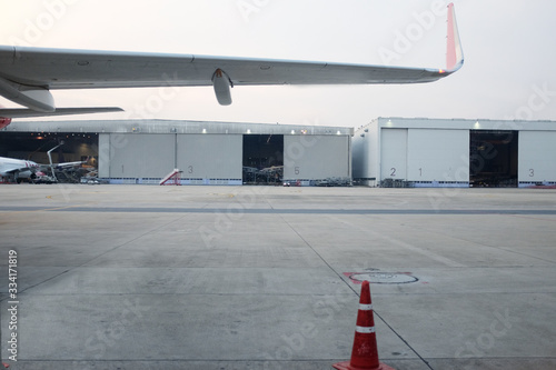 Parked aircraft near the hangar. Cargo plane on the airfield. Commercial air freight. Sunset spotting at the airport. - Image