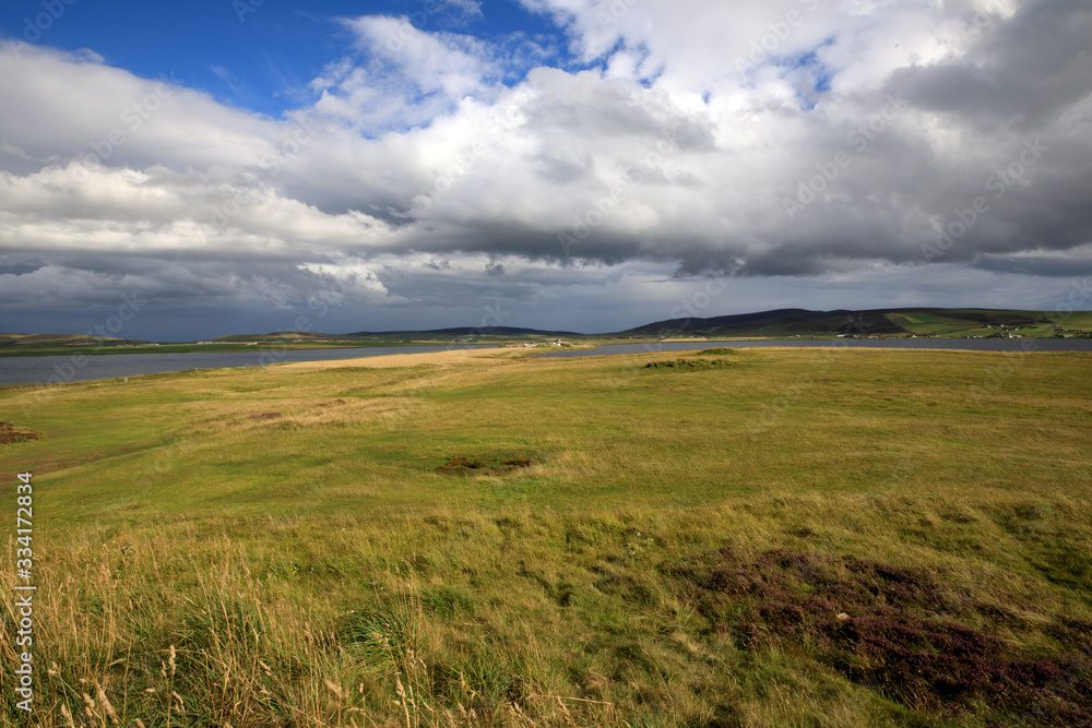 Brodgar - Orkney (Scotland), UK - August 06, 2018: The country near Ring of standing stones at Brodgar, Orkney, Scotland, Highlands, United Kingdom Brodgar - Orkney (Scotland), UK - August 06, 2018: The country near Ring of standing stones at Brodgar, Orkney, Scotland, Highlands, United Kingdom