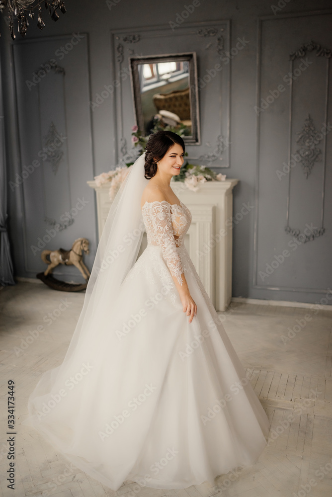 Full-length portrait of a bride in a vintage interior. Lovely young bride is enjoying wedding day, smiling and looking forward. Beautiful bride portrait.