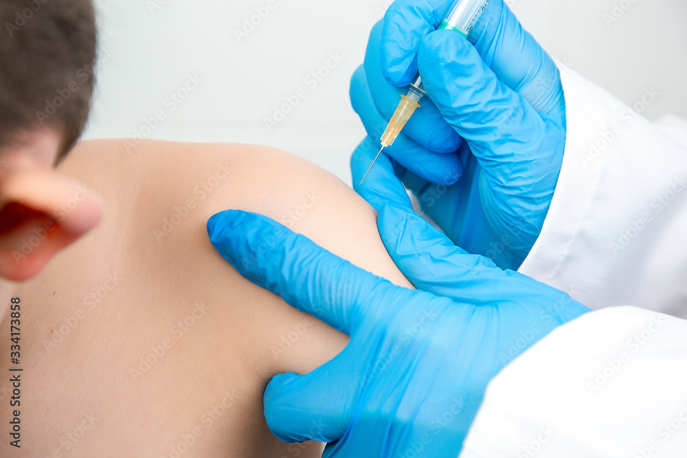 Portrait of a nurse vaccinating a child in hospital. Vaccine against coronavirus (covid-19) or other disease Portrait of a nurse vaccinating a child in hospital. Vaccine against coronavirus (covid-19) or other disease