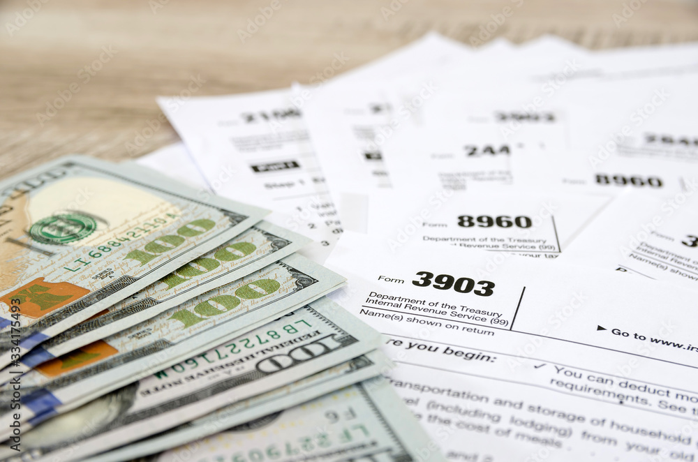 different tax forms and dollars on a wooden background. Business concept. different tax forms and dollars on a wooden background. Business concept.