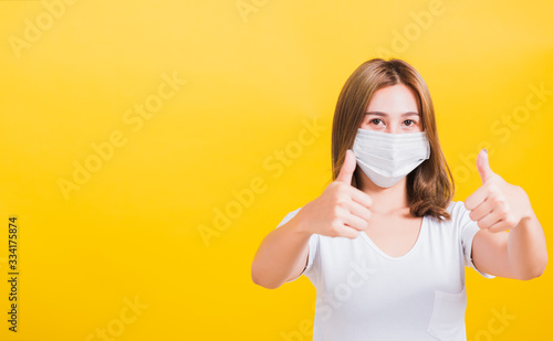 woman wearing mask protection, show thumb finger good stopping virus outbreak control