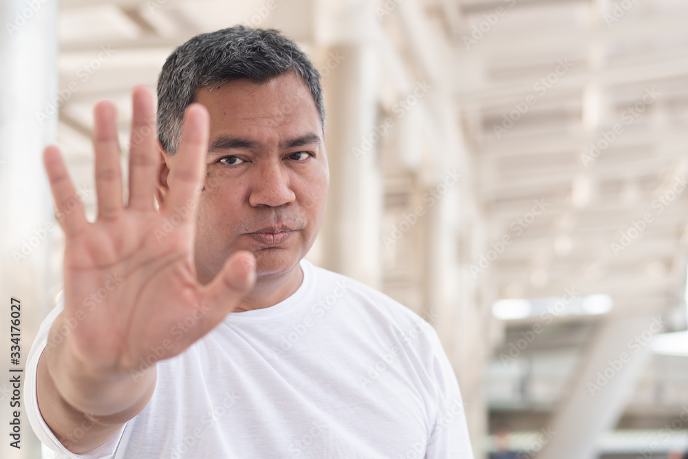old man showing rejecting, stopping hand gesture; concept of forbidding, no way, rejection, negative answer, halt, stop, warning, social distancing; southeast asian senior old man model old man showing rejecting, stopping hand gesture; concept of forbidding, no way, rejection, negative answer, halt, stop, warning, social distancing; southeast asian senior old man model