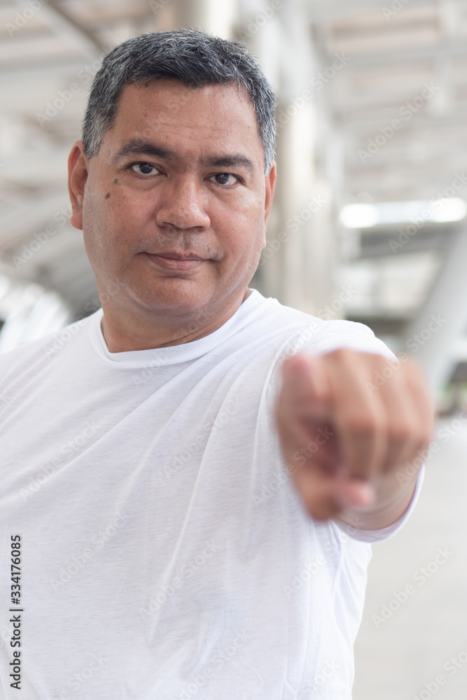 Fototapeta premium old senior man pointing at you; confident serious senior man pointing index finger for concept of selecting, choice, choosing, decision making; southeast asian senior old man model