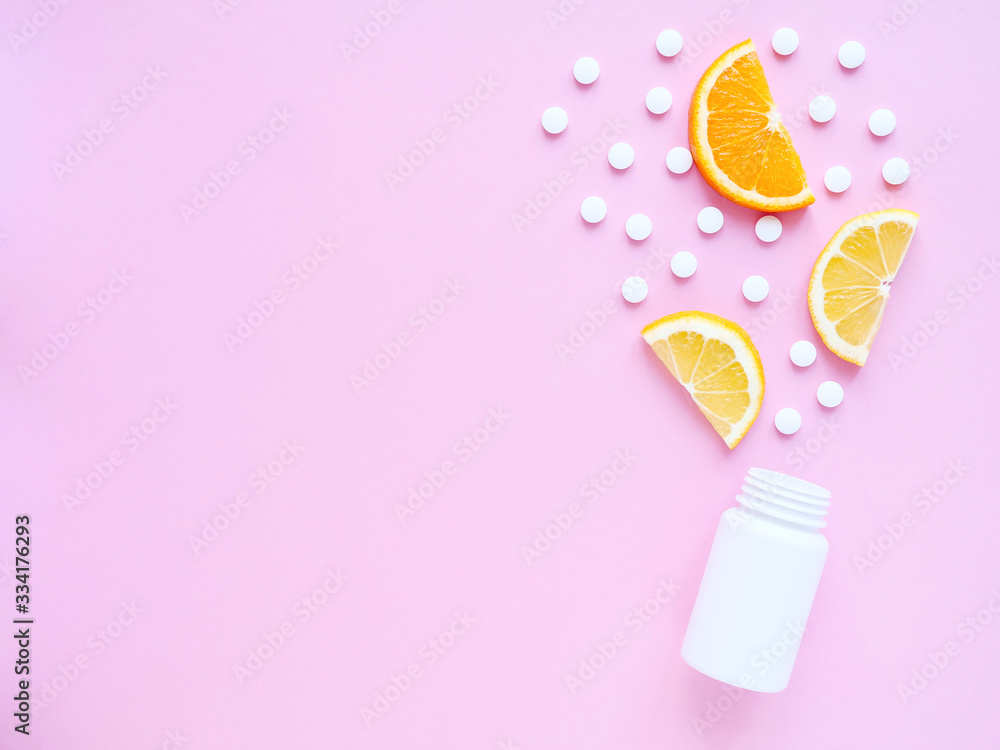 scattered vitamin pills from bottle with lemon and orange on pink background. Copyspace, flat lay. Concept boost immune system, medicine and tablets. scattered vitamin pills from bottle with lemon and orange on pink background. Copyspace, flat lay. Concept boost immune system, medicine and tablets.