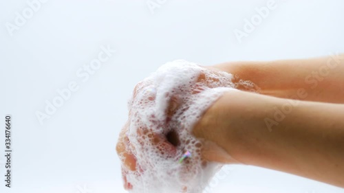 Close up of female lathering hands with soap before washing 