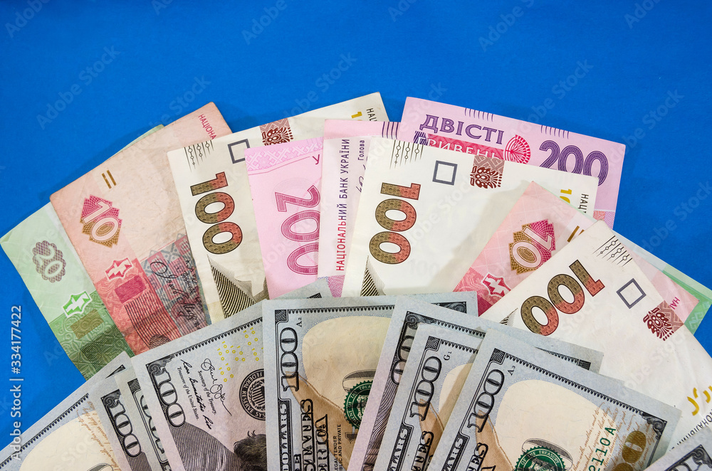 different hryvnias and dollars on a blue background. Business concept. different hryvnias and dollars on a blue background. Business concept.