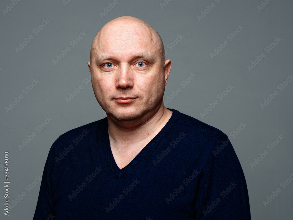 Portrait of a bald cheerful man on a gray background Portrait of a bald cheerful man on a gray background