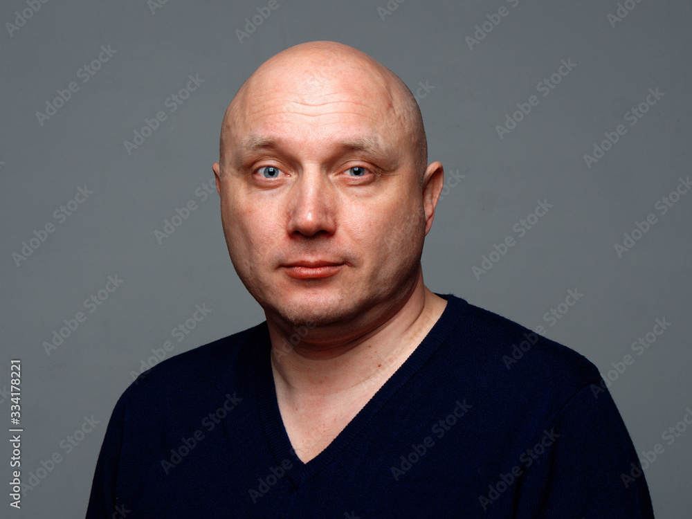 Portrait of a bald cheerful man on a gray background Portrait of a bald cheerful man on a gray background
