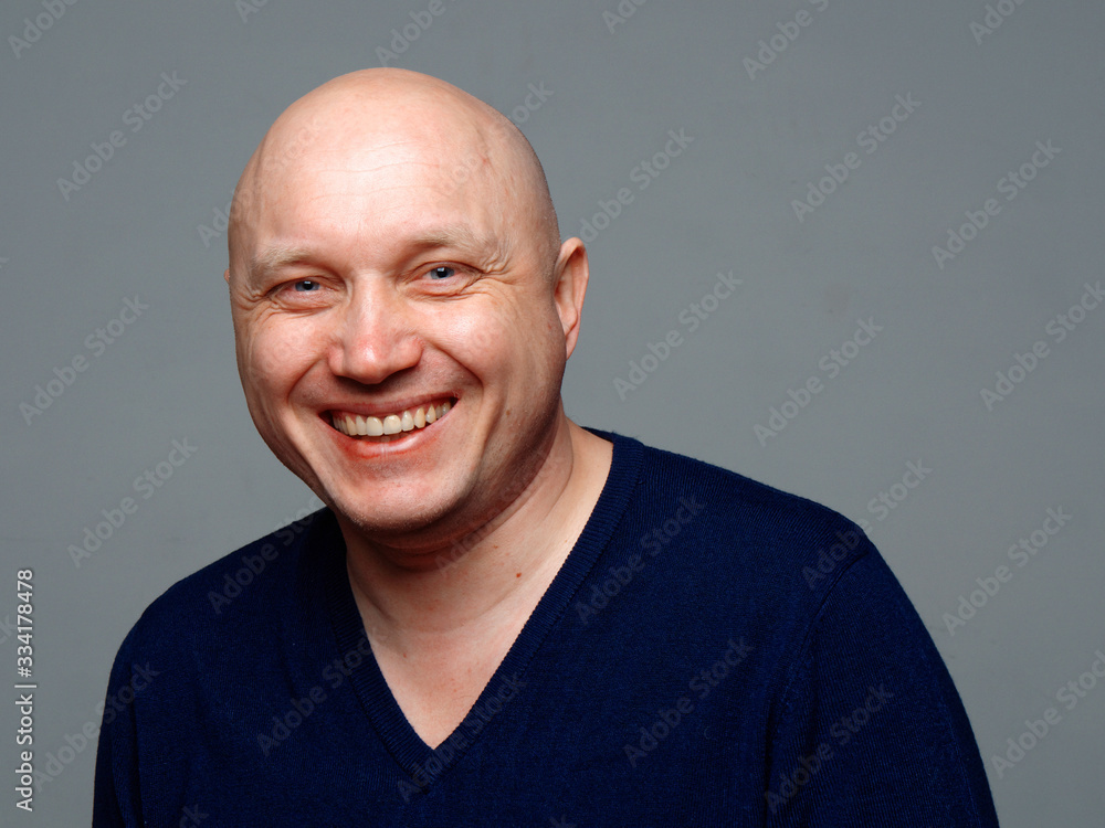 Portrait of a bald cheerful man on a gray background Portrait of a bald cheerful man on a gray background