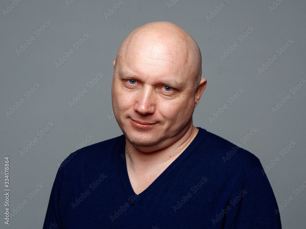 Portrait of a bald cheerful man on a gray background Portrait of a bald cheerful man on a gray background
