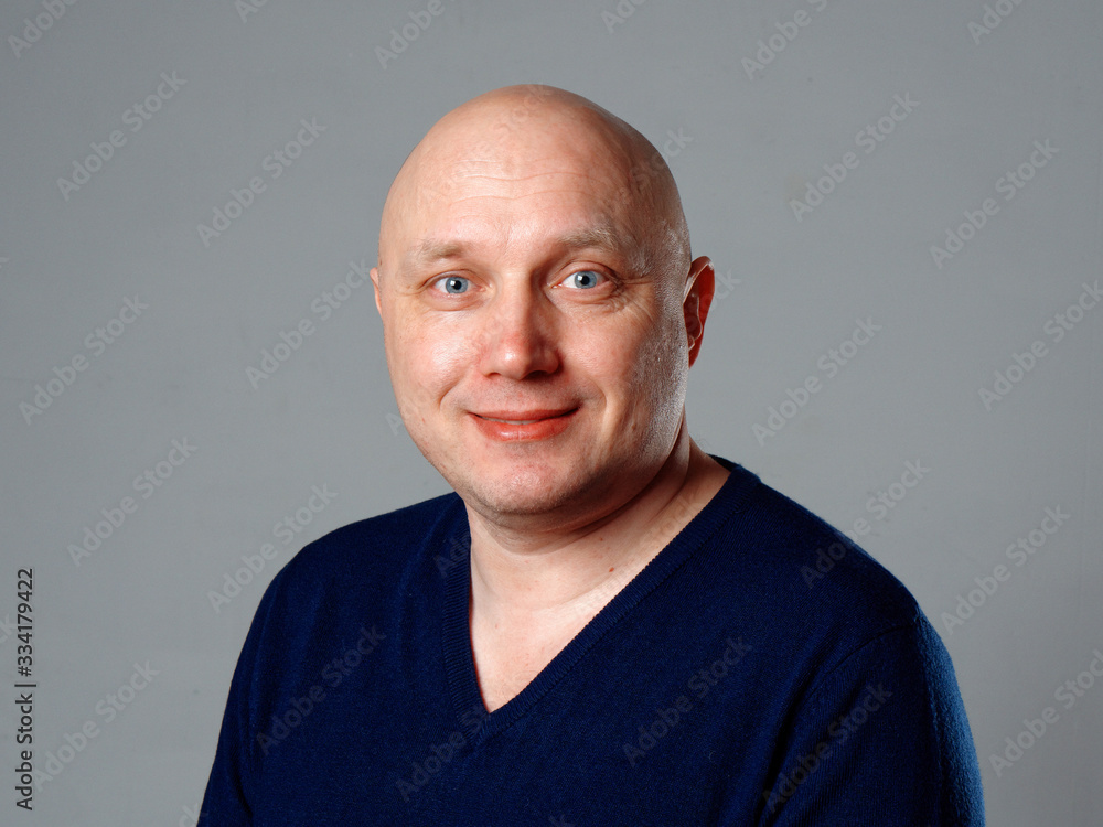 Obraz premium Portrait of a bald cheerful man on a gray background