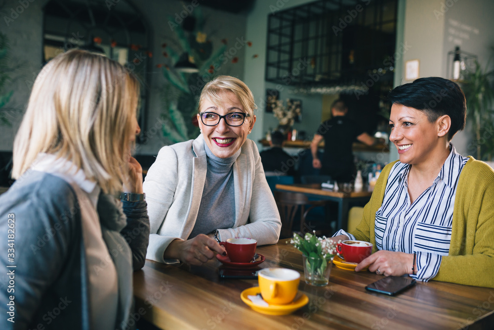 women talking in cafe while drinking coffee