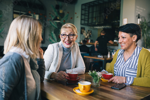 women talking in cafe while drinking coffee