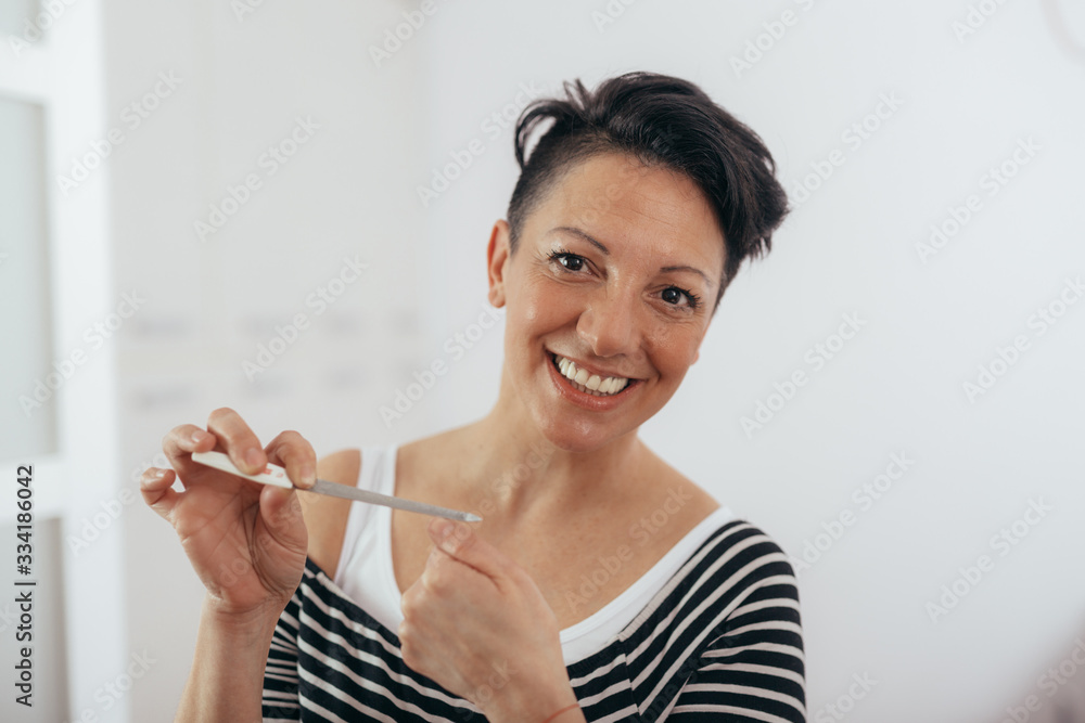middle aged woman polishing nails