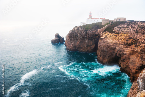 Lighthouse on Cape St. Vincent in foggy evening in Algarve, Portugal. This is the most South-Western point of Europe