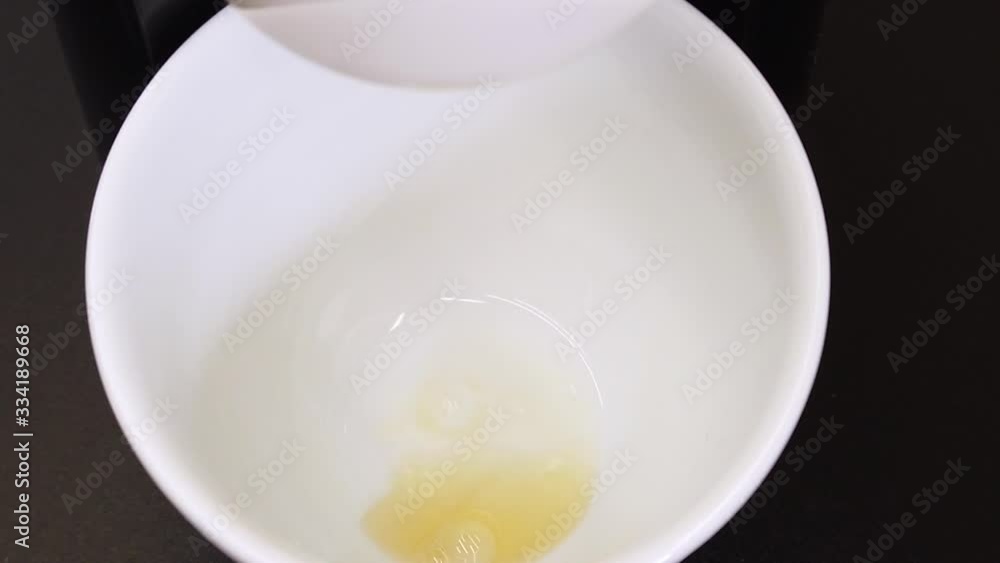 beginning of brewing espresso with a coffee machine into a white cup on black background, starting with Pre-Infusion flow, slow motion, view from top inside a mug beginning of brewing espresso with a coffee machine into a white cup on black background, starting with Pre-Infusion flow, slow motion, view from top inside a mug