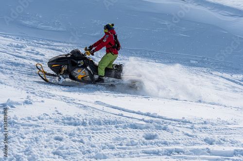 Snowmobile ride in spring on the mountainside in bright daylight