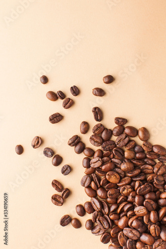 Coffee beans in the lower corner on a brown background. Vertical photo with space for text. For coffee houses and cafes.