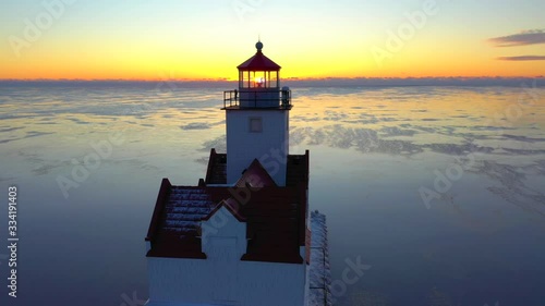 Iconic Lighthouse standing tall in frozen Lake Michigan harbor, Winter dawn. photo