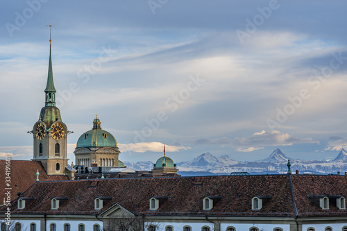 Obraz na płótnie Blick auf das Bundeshaus und Heiliggeistkirche im Abendlicht vor Bergkulisse – Bern, Schweiz w salonie