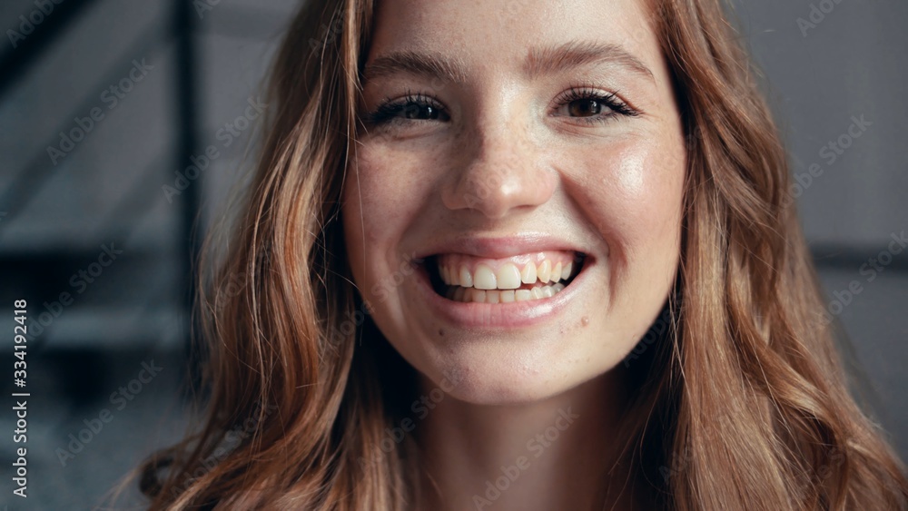 Portrait young woman at sunlight with curly hair open eyes look at camera smiling fashion model female girl cosmetic beauty confident happy cheerful close up Portrait young woman at sunlight with curly hair open eyes look at camera smiling fashion model female girl cosmetic beauty confident happy cheerful close up