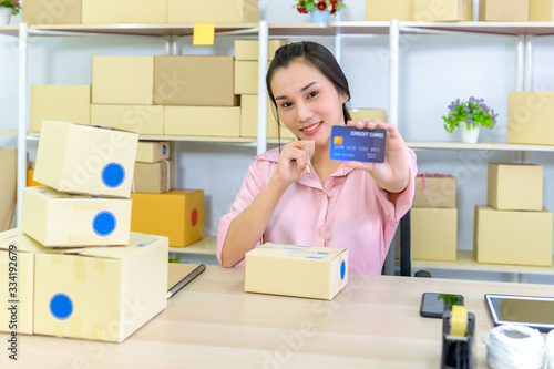Young woman holding credit card and using laptop computer, Happy woman doing online shopping at home, Online shopping concept..