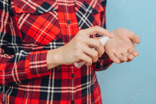 Women's hands use a sanitizer to cleanse their hands of germs. Hygiene rule in the Covid-2019 epidemic. Hand disinfection with an aerosol sanitizer. coronavirus pandemic. © Stanislav