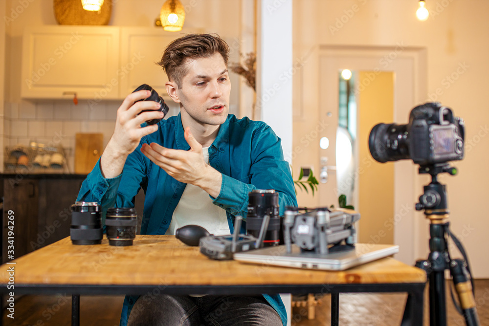 caucasian blogger keen on photographing, he show different DSLR on camera and talk about pros, cons. how to use and which of them is the most useful caucasian blogger keen on photographing, he show different DSLR on camera and talk about pros, cons. how to use and which of them is the most useful