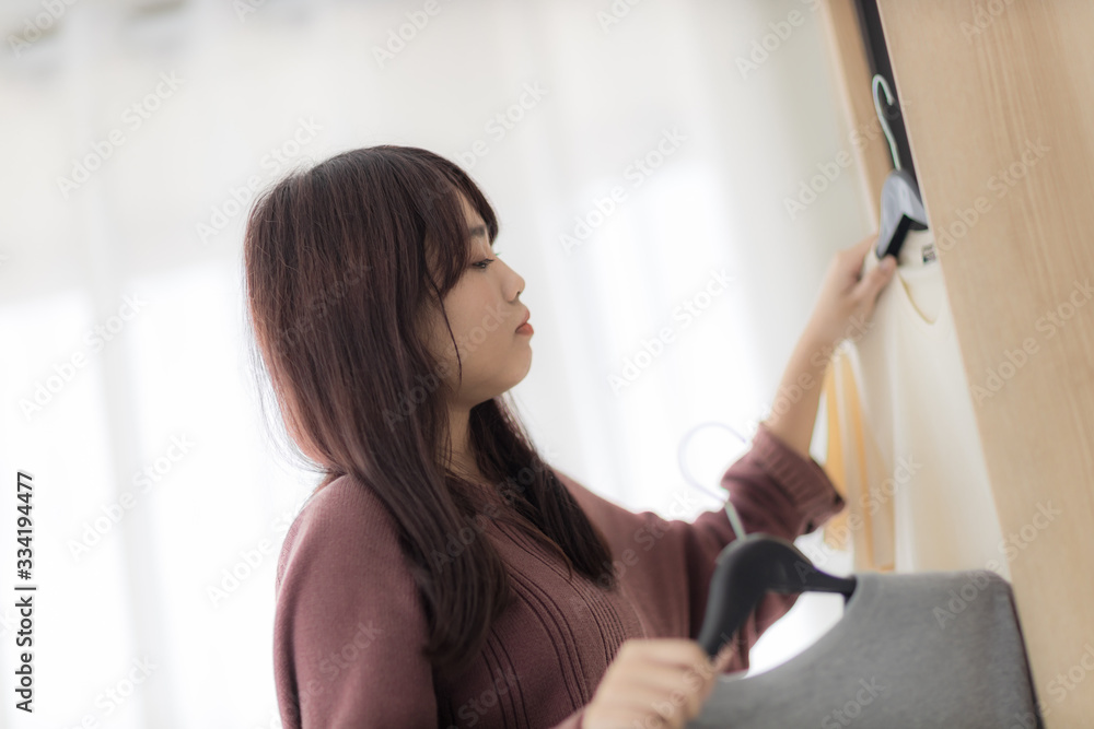 asian woman, housewife is putting the t-shirt in the closet. asian woman, housewife is putting the t-shirt in the closet.