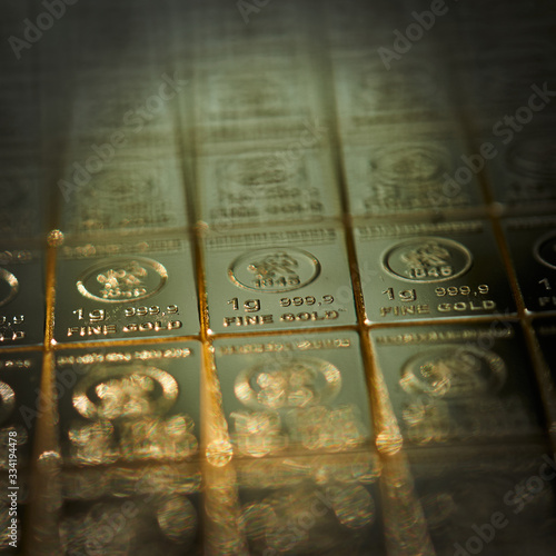 Table of 1-gram pieces of 999 pure fine gold, selective focus on the middle piece, intentional edge blur photo