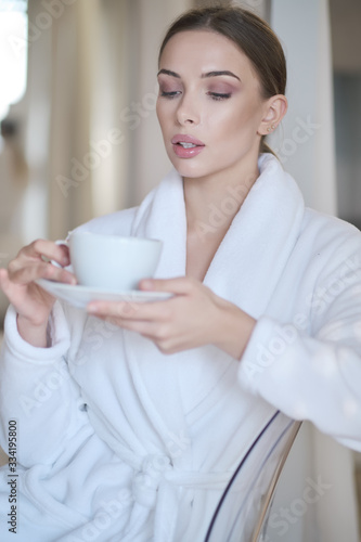 woman resting in a bathrobe at home