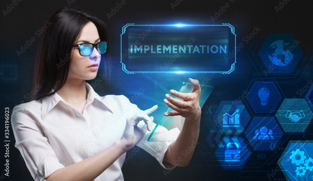 Business, Technology, Internet and network concept. Young businessman working on a virtual screen of the future and sees the inscription: Implementation Business, Technology, Internet and network concept. Young businessman working on a virtual screen of the future and sees the inscription: Implementation