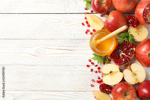 Apple, pomegranate and honey on wooden background, top view