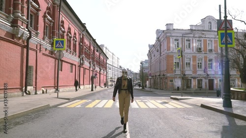 A girl in a gas mask walks along the carriageway in the center of Moscow on Petrovka Street and protects herself from the viral epidemic of the coronavirus COVID-19 with a gas mask made in the USSR. photo