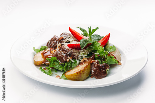 salad of pears, strawberries and greens on a white background