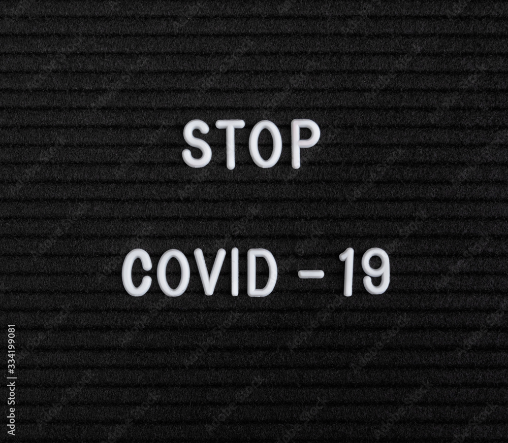 The words Stop Covid-19 on black felt letter board The words Stop Covid-19 on black felt letter board