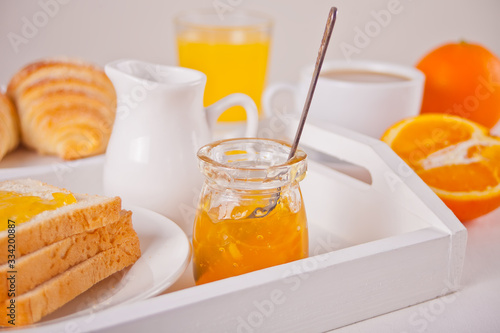 Bread toast with orange jam, glasses of orange juice on the white background. Breakfast concept.