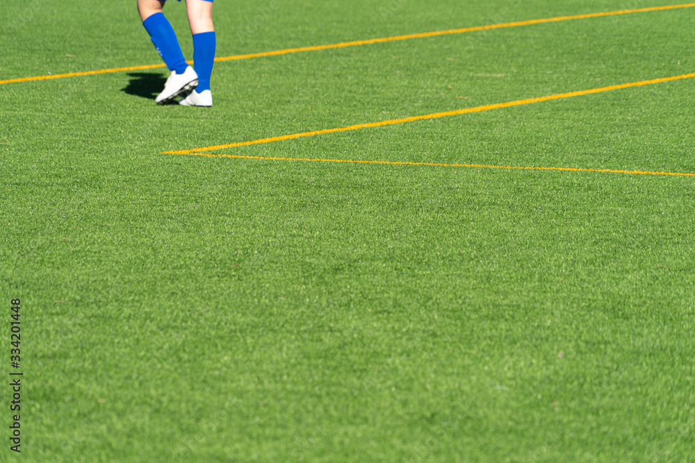 Obraz premium Youth soccer player feet on empty green grass football practice ground