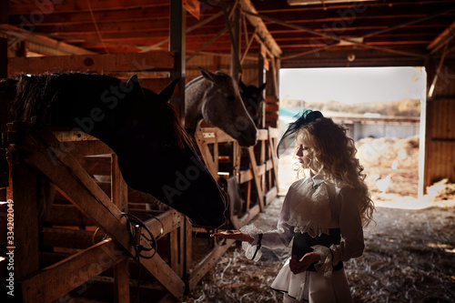 Beautiful blonde girl in the stable. Horseback Riding.