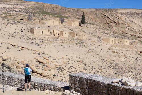 Femme marchant vers des habitations bédouines