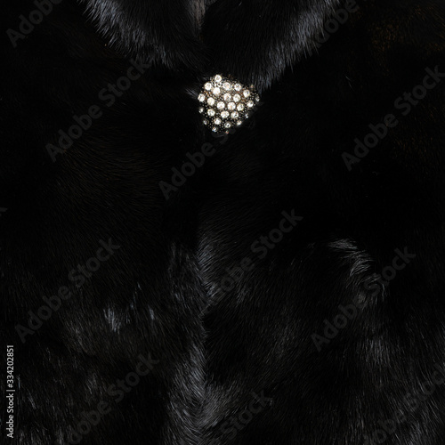 Texture of natural black shiny fur with beautiful wavy folds and a sparkling button on top © Павел Круглов