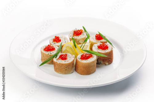 stuffed pancakes with caviar and lemon slices on a white background