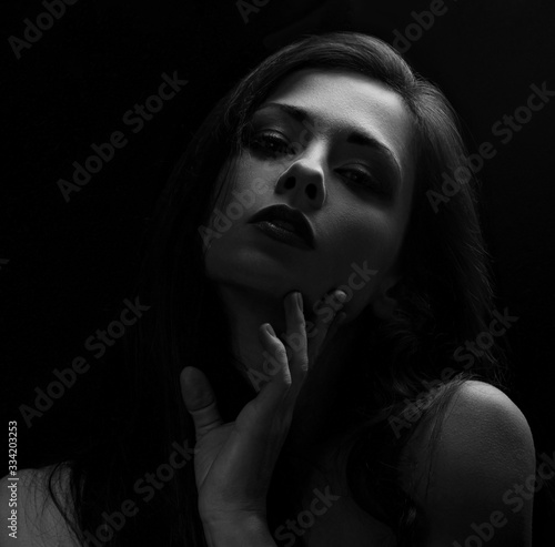 Beautiful makeup sexy woman with long hair looking with red lipstick on black background. Closeup portrait. Art.Expression portrait