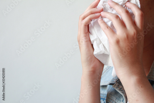 Close up sick young woman has runny nose, blowing her nose into paper.common cold, flu, allergies, sinusitis, asthma, air pollution or influenza. Healthcare concept.  © jajam_e