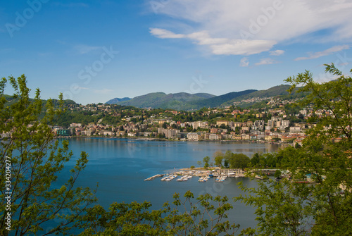 View of the lake and the city of Lugano on a sunny summer day. Mountain landscape in the city of Lugano  Switzerland. 