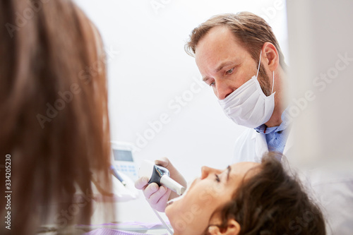 Dentist and dental assistant during teeth whitening