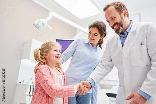 Frightened child salutes dentist with handshake
