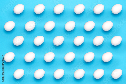 White eggs in a abstract pattern on blue background